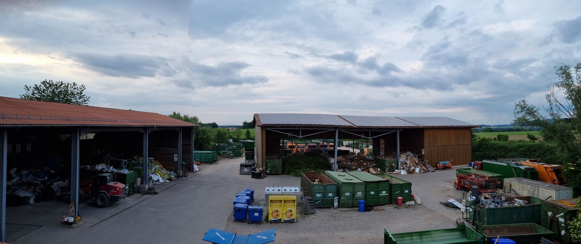 Ein Wertstoffhof mit grünen Containern